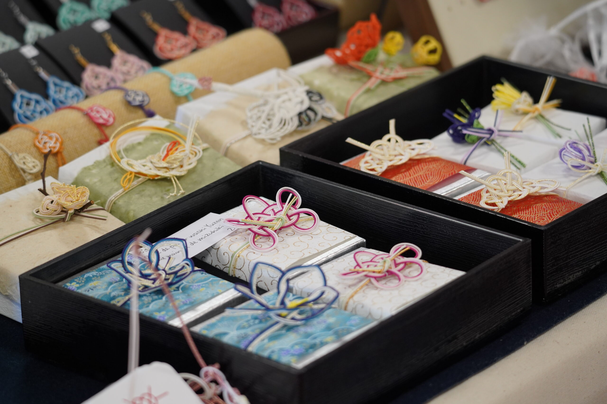 Créations en mizuhiki, noeuds traditionnels japonais en papier amidonné pour décorer les cadeaux et enveloppes.